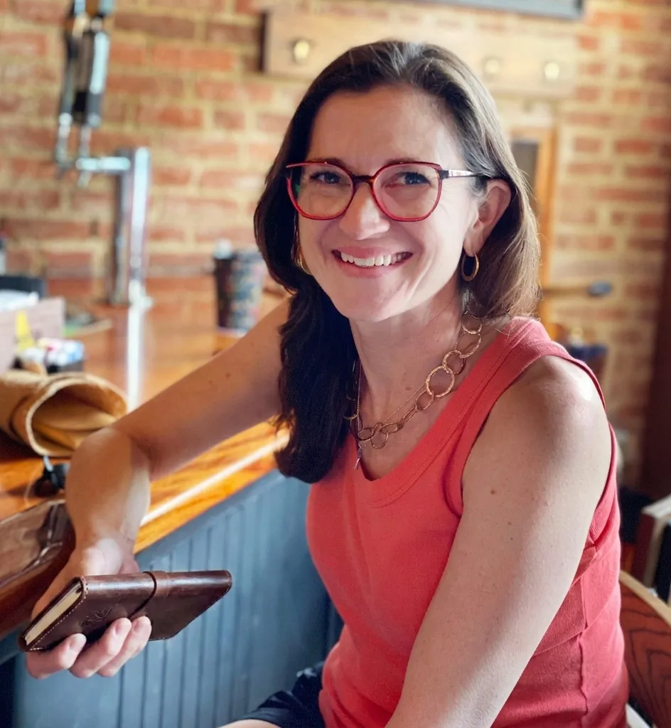 Amanda from Gather to Travel planning a bespoke itinerary in a rustic travel journal.